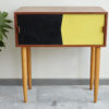 Black and yellow Swedish dresser with plant