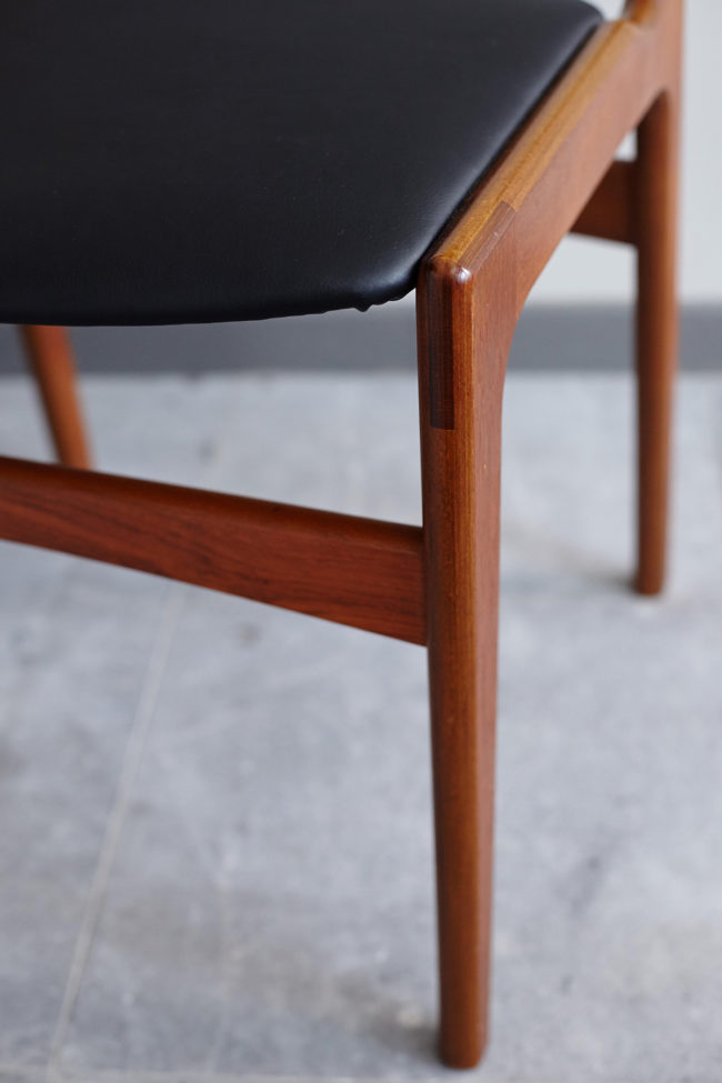 Close up of seat and frame of Danish black skai dining chair at an angle
