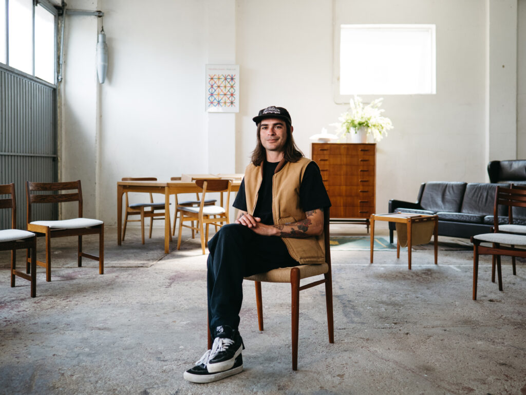Portrait of Loucas Polydorou, artisan and business owner, amongst Danish mid-century furniture