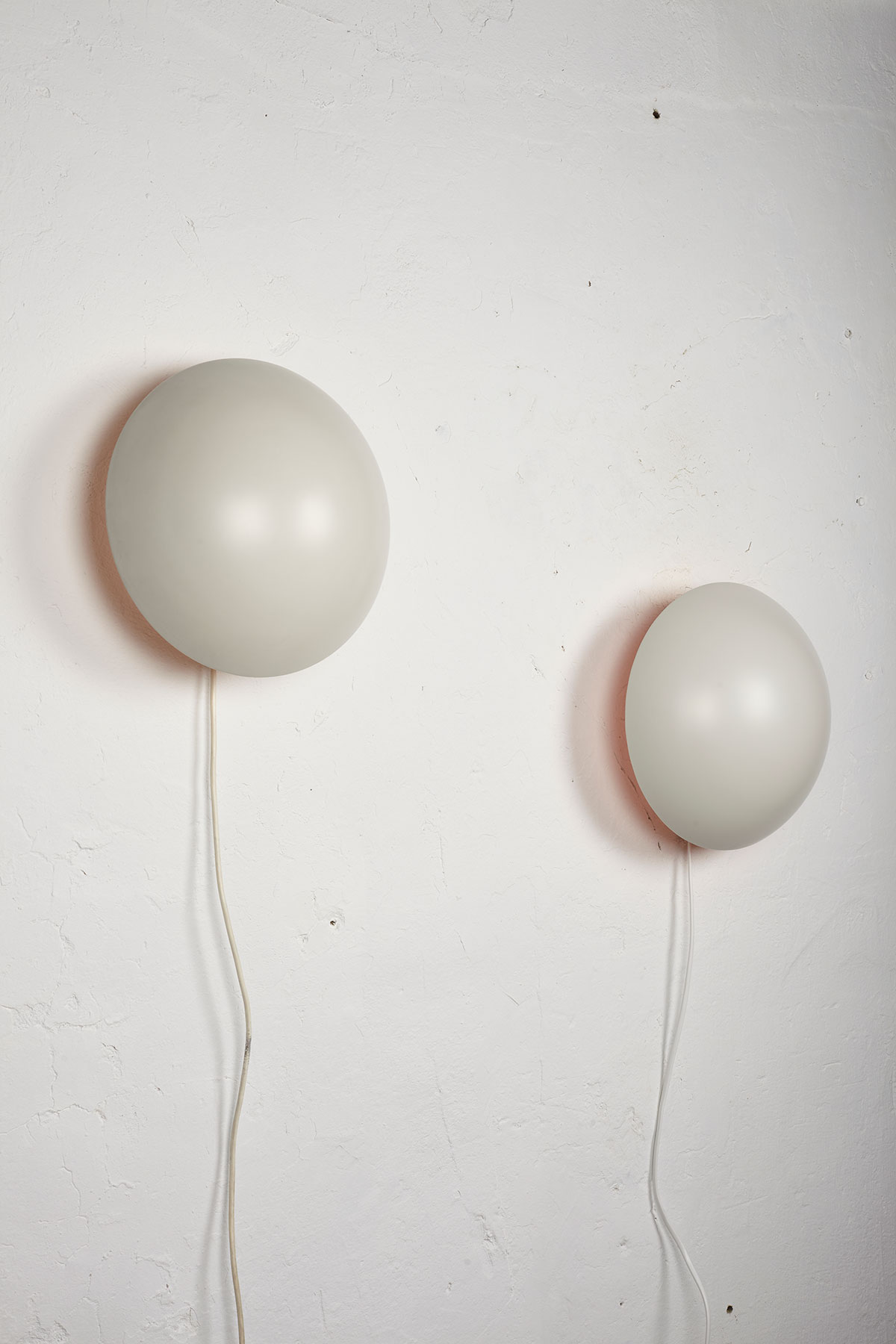 Set of two P Hat wall lamps mounted on a white wall