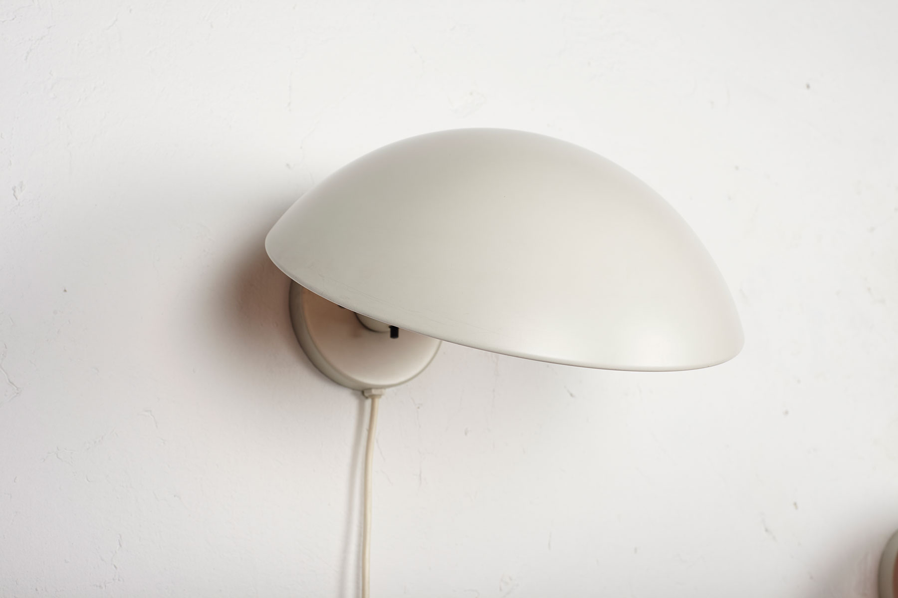 P Hat wall lamps mounted on a white wall